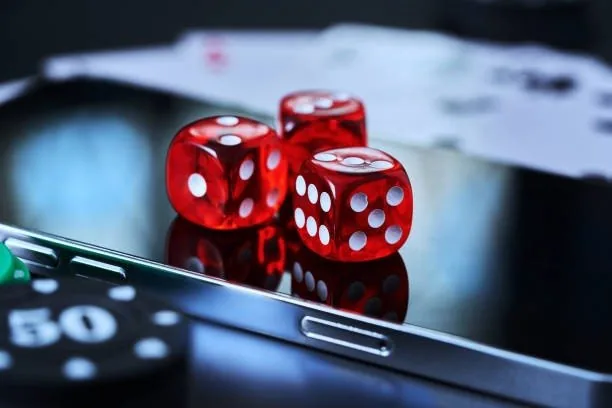 Red dice resting on a smartphone screen