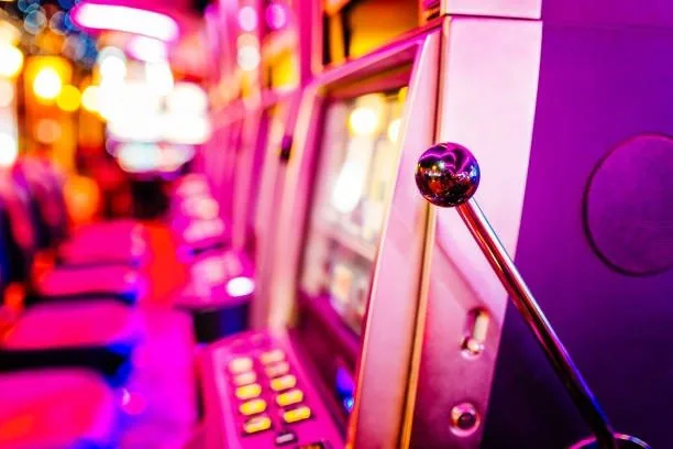 Slot machine lever under pink and orange lights